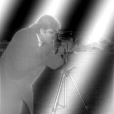 Cameraman photo with soft, rolling black and white diagonal bands
overlaid on image, which is otherwise compressed towards middle gray.