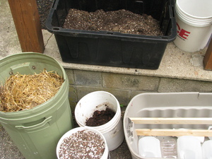 Various bins and buckets with soil components or amendments, described below